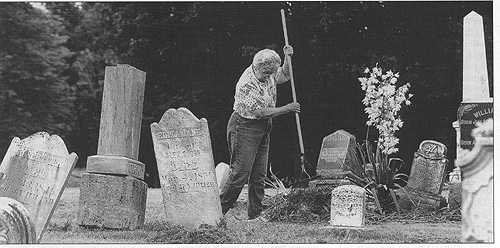 Jane King of Auburn rakes grass and weeds that were cut during a cleanup day at Wimmer Cemetery, a private cemetery in Auburn
Township. Revolutionary War and Civil War veterans are buried in this cemetery, which the township helps maintain for Auburn families.
Photograph by Chris Young, courtesy of The State Journal-Register of Springfield.